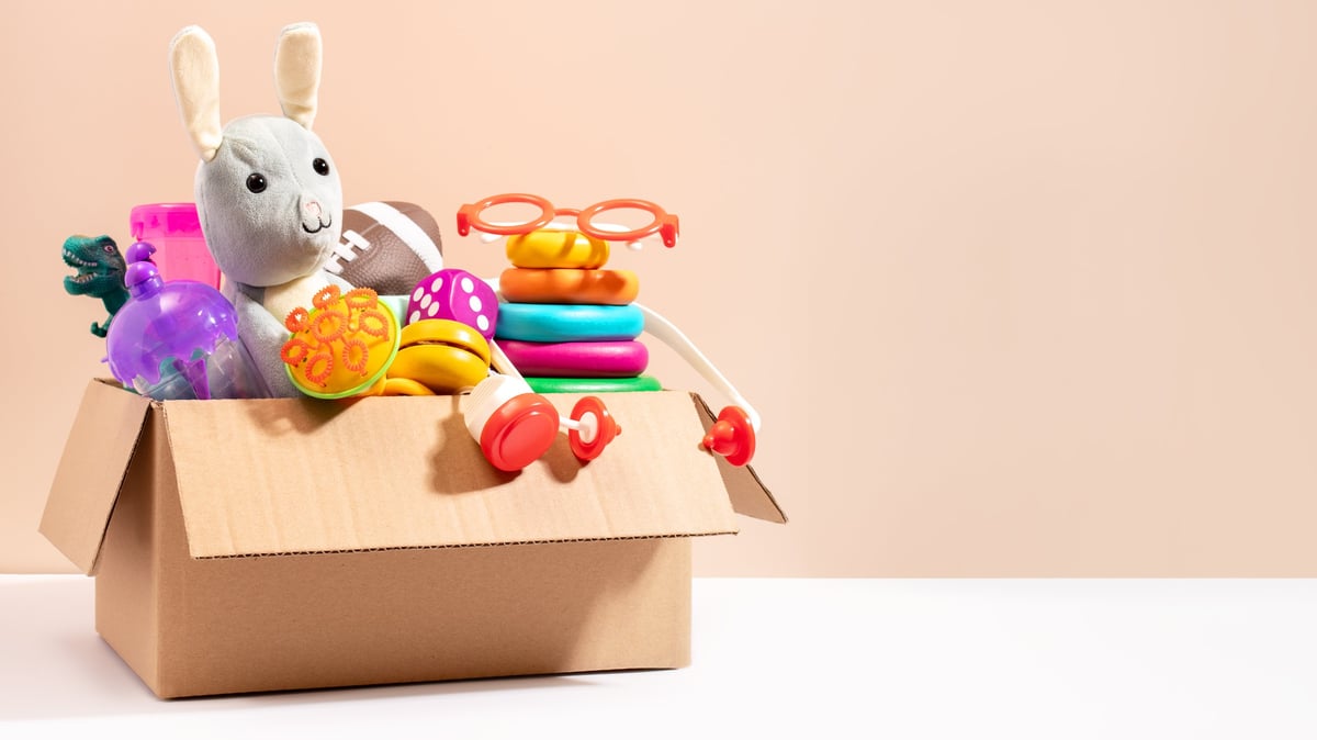 Children's toys packed in a box against a beige background